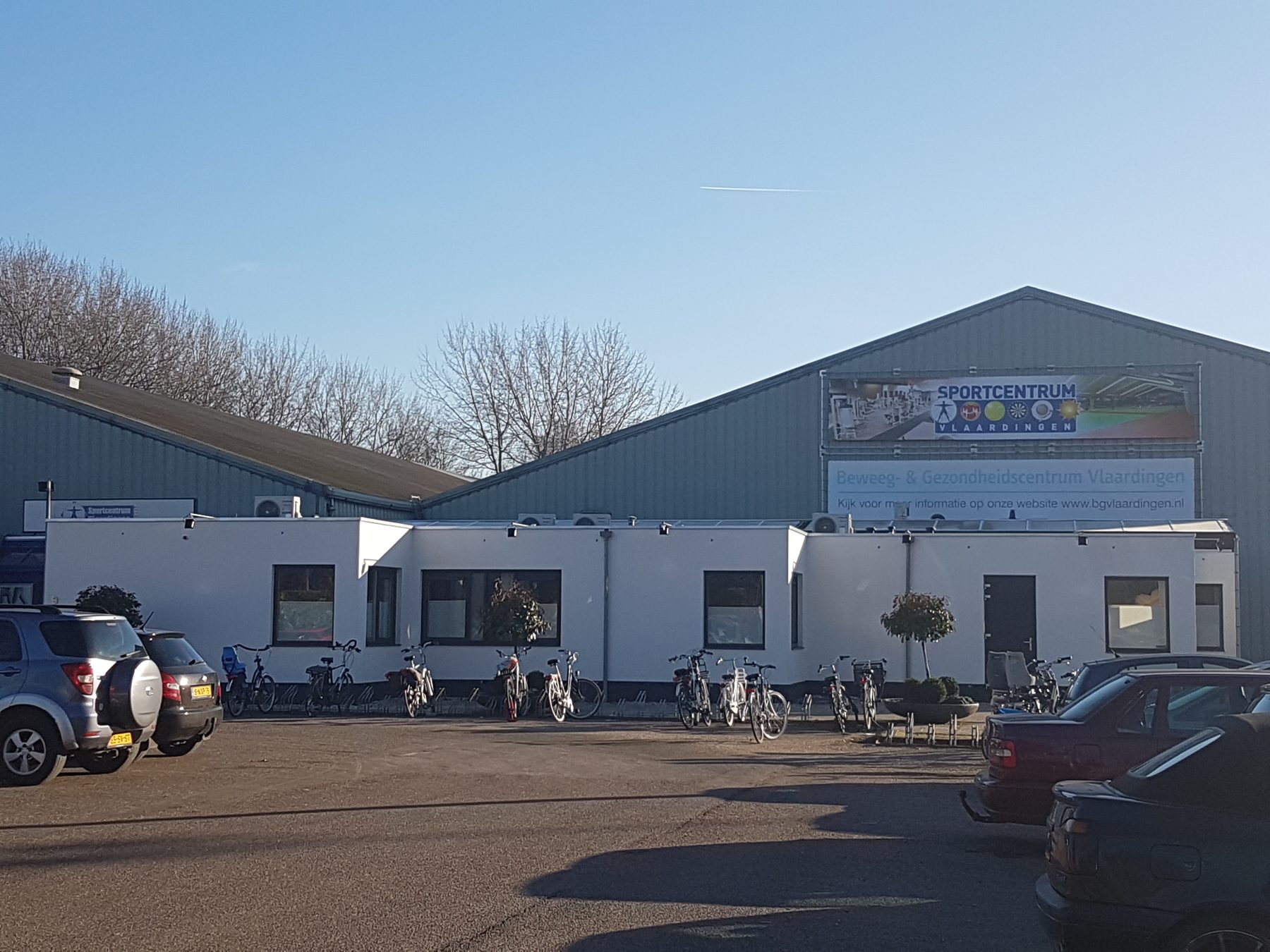 De ingang van Sportcentrum Vlaardingen, met parkeerplaatsen ervoor